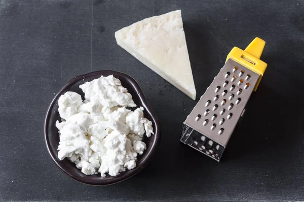 Queijo parmesão ralado e ralador em fundo de madeira — Fotografia de Stock