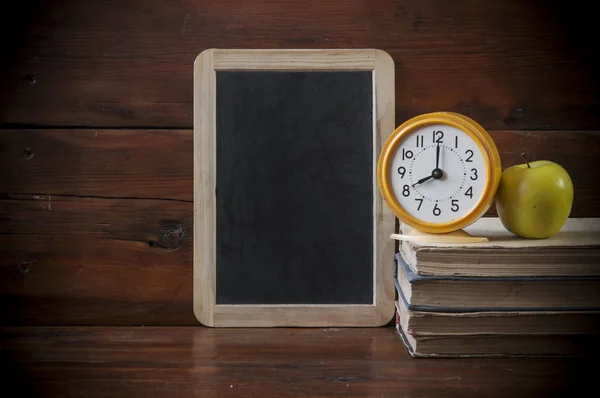 Terug naar school achtergrond met boeken en de wekker over chalkb — Stockfoto