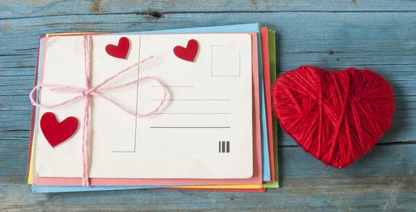 mektup zarfı ahşap arka plan üzerinde kırmızı kalpli seviyorum