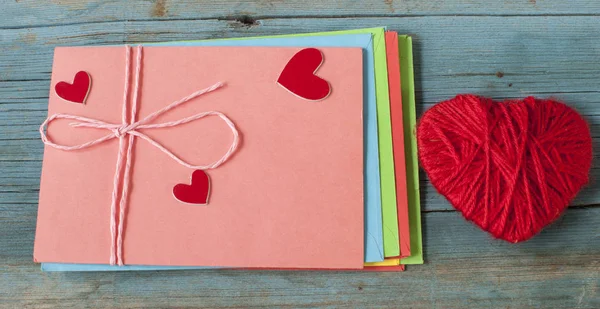 mektup zarfı ahşap arka plan üzerinde kırmızı kalpli seviyorum