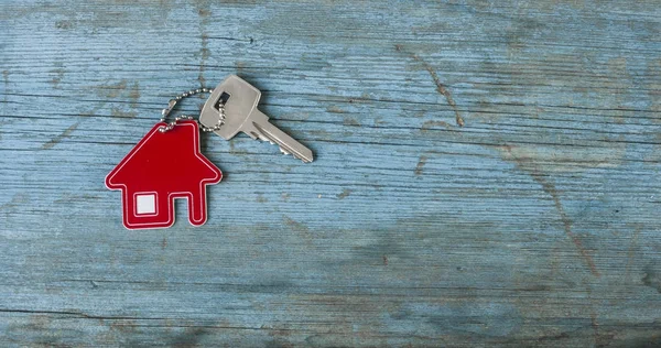 Llave con icono de la casa sobre fondo de madera — Foto de Stock