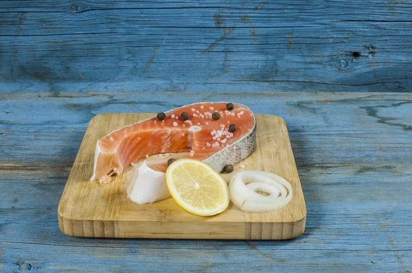 Fresh raw salmon steaks with salt, peppers, lemon — Stock Photo, Image