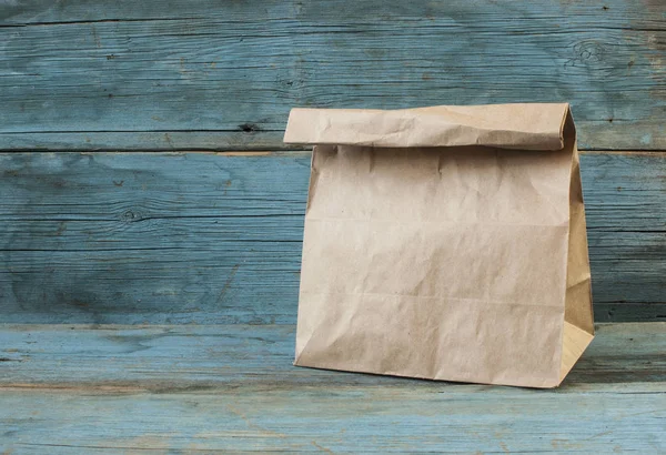 Paper bag on old wooden background — Stock Photo, Image