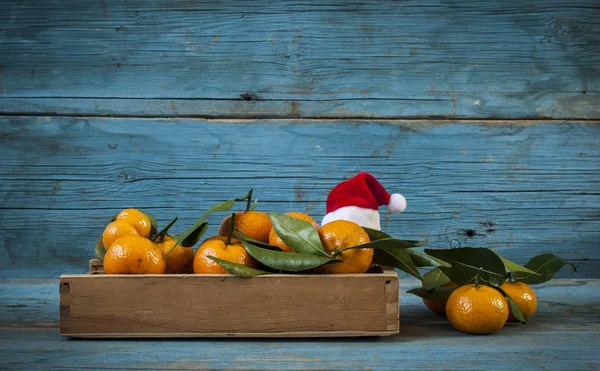Mandarini freschi in una vecchia scatola con foglie — Foto Stock