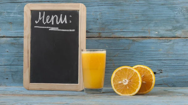 Chalk board, and fresh orange juice in glasses — Stock Photo, Image