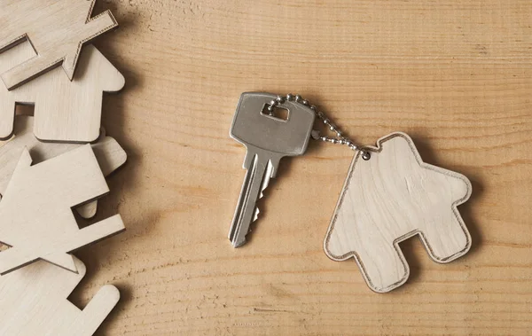 Nyckel med hussymbol på trä bakgrund — Stockfoto