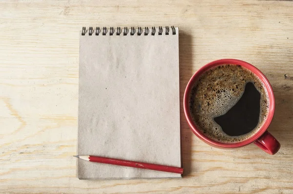 Kop koffie op houten achtergrond met lege opmerking, bovenaanzicht — Stockfoto