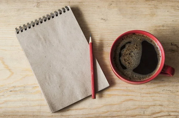Kop koffie op houten achtergrond met lege opmerking, bovenaanzicht — Stockfoto