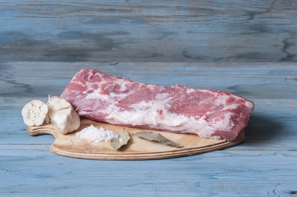 Çiğ et. Çiğ domuz biftek tuz ve baharatlar ile siyah. — Stok fotoğraf