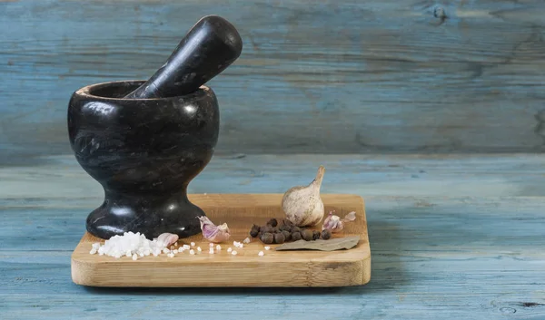 Stone mortar with a pestle on a wooden cutting board — Stock Photo, Image