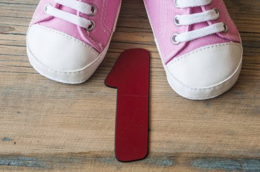 ahşap arka plan üzerinde renkli yürümeye başlayan çocuk ayakkabı