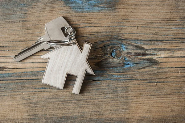 Ключ з значком будинку на дерев'яному фоні — стокове фото