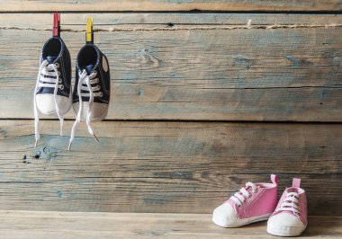 Çamaşır ipinde asılı bebek ayakkabıları.