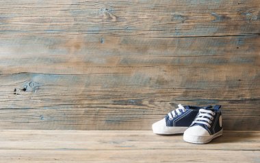 Çamaşır ipinde asılı bebek ayakkabıları.