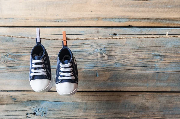 Chaussures de bébé accrochées à la corde à linge. — Photo