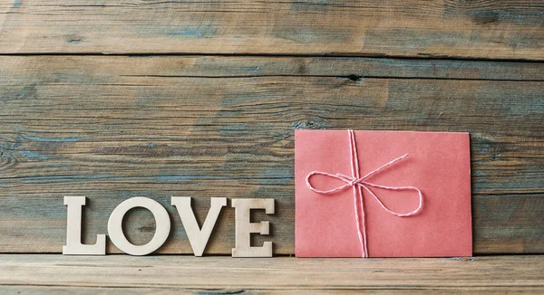 Słowa miłości powiesić z liny na tle drewna (Walentynki) — Zdjęcie stockowe