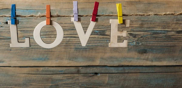 Worte Liebe hängen mit Seil auf Holz Hintergrund (Valentinstag) — Stockfoto