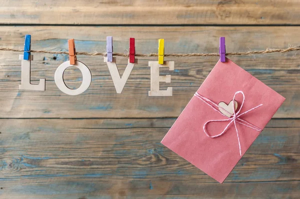 Woorden van liefde hangen met touw hout achtergrond (de dag van Valentijnskaarten) — Stockfoto