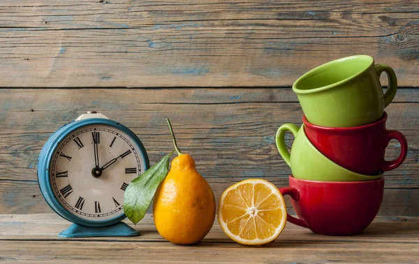 Limones frescos maduros y taza de té colorida —  Fotos de Stock