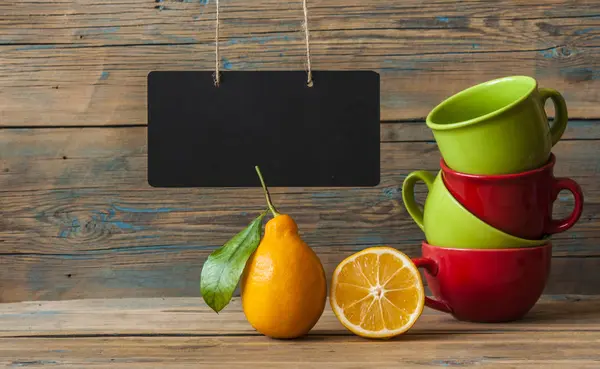 Limões maduros frescos e xícara de chá colorido — Fotografia de Stock