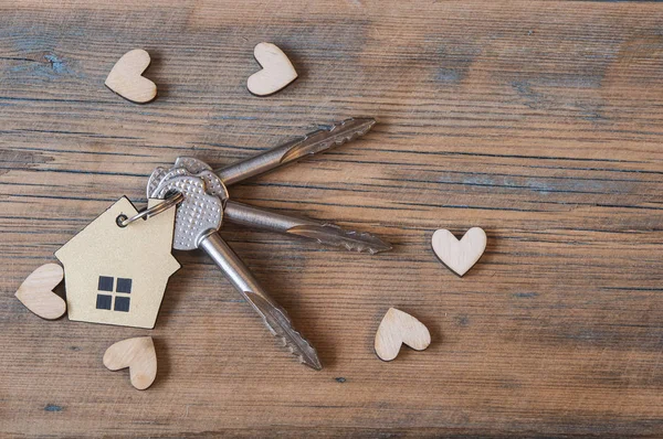 Llave con icono de la casa sobre fondo de madera — Foto de Stock