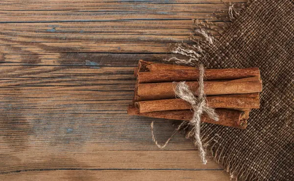 Palos de canela racimo atado con cuerda sobre un fondo oscuro — Foto de Stock