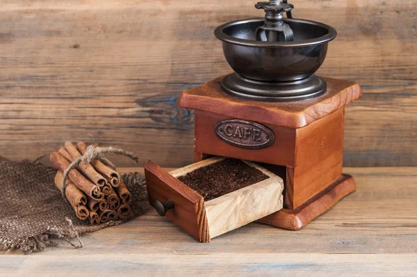 Stilleven met koffiebonen en oude koffiemolen op houten tafel — Stockfoto