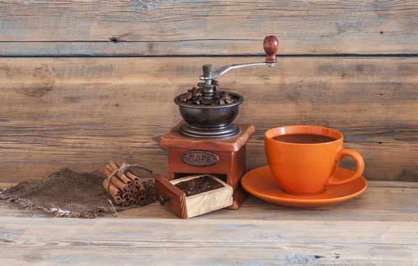 Stillleben mit Kaffeebohnen und alter Kaffeemühle auf Holztisch — Stockfoto