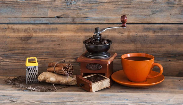 Stilleven met koffiebonen en oude koffiemolen op houten tafel — Stockfoto