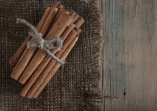 Palos de canela racimo atado con cuerda sobre un fondo oscuro — Foto de Stock