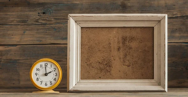 Wood photo frame and clock on wooden table — Stock Photo, Image