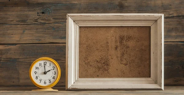 Marco de fotos de madera y reloj en mesa de madera — Foto de Stock