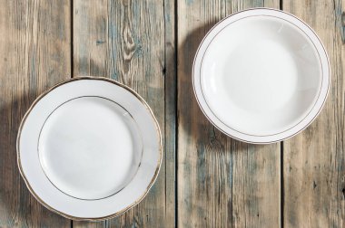 Ahşap bir arka planda boş beyaz tabak.