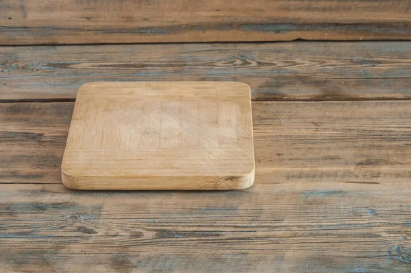 Tabla de cortar madera sobre fondo de madera — Foto de Stock