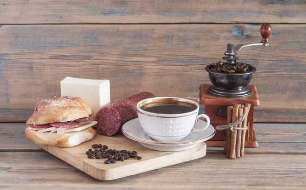 Uma xícara de café com belo sanduíche de salsicha pela manhã — Fotografia de Stock