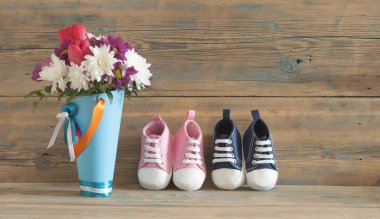 Güzel taze bahar çiçekleri ve bir tahta üzerinde çocuk ayakkabı 