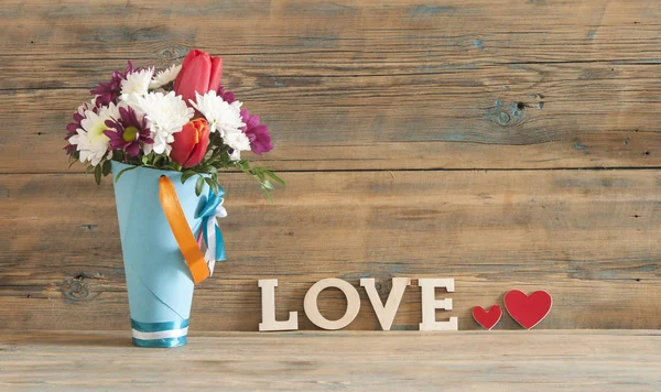 Ordet kärlek, blommor och trä bakgrund — Stockfoto