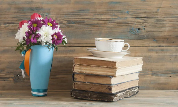 Beautiful fresh spring flowers with stack of books on a table — Stock Photo, Image