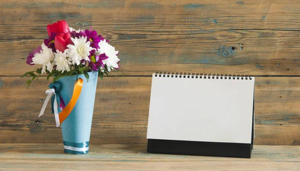 Calendario en blanco con flor en jarrón en la mesa — Foto de Stock