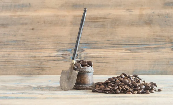Gebrande koffiebonen schop houten achtergrond — Stockfoto
