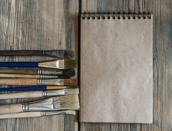 Notebook e acessórios da escola sobre fundo de madeira — Fotografia de Stock