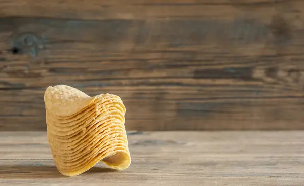 Gouden natuurlijke potato chips op een oud houten tafel — Stockfoto