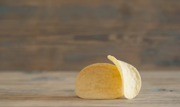 Золоті натуральні картопляні чіпси на старому дерев'яному столі — стокове фото
