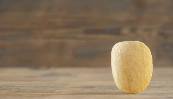 Golden natural potato chips on an old wooden table — Stock Photo, Image