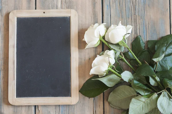 Witte rozen op een oude witte houten tafel — Stockfoto