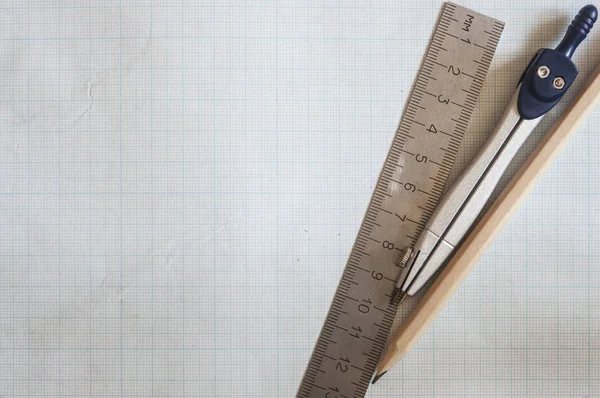 Pencil, compass and rulers on graph paper background — Stock Photo, Image