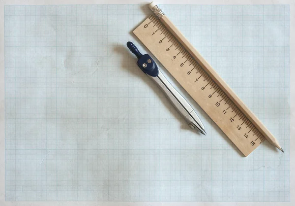 Ołówek, kompas i władców na tle papier milimetrowy — Zdjęcie stockowe