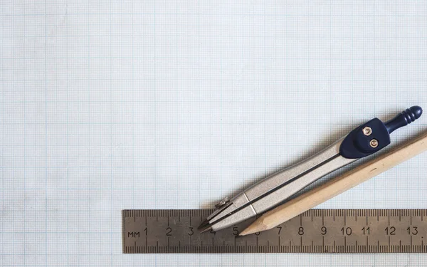 Pencil, compass and rulers on graph paper background — Stock Photo, Image