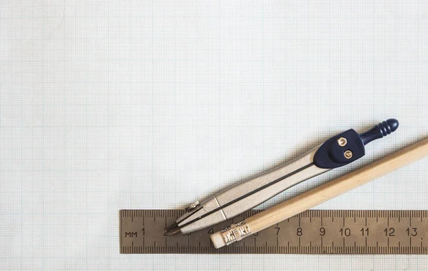 Pencil, compass and rulers on graph paper background — Stock Photo, Image