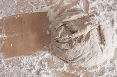 Masanın üzerinde hamur mayaları ham buğday un serpilir